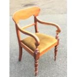 A Victorian mahogany elbow chair with shaped back rail above scrolled arms on vase shaped