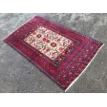 An oriental rug woven with field of birds, flowers and stylised symbols on fawn ground, framed by