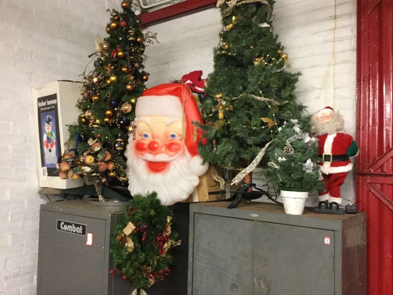 A quantity of Christmas decorations including two trees, a giant lighting up Santa head, tinsel,