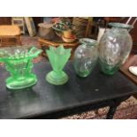 A deco green glass vase of flared shape supported by a pair of frosted mermaid style figures holding