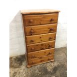 A pine chest with shaped moulded top above six knobbed drawers, raised on bun feet. (24in x 17in x