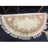 A ‘D’ shaped wool hearth rug woven with floral frieze on ivory ground, having tasseled outer