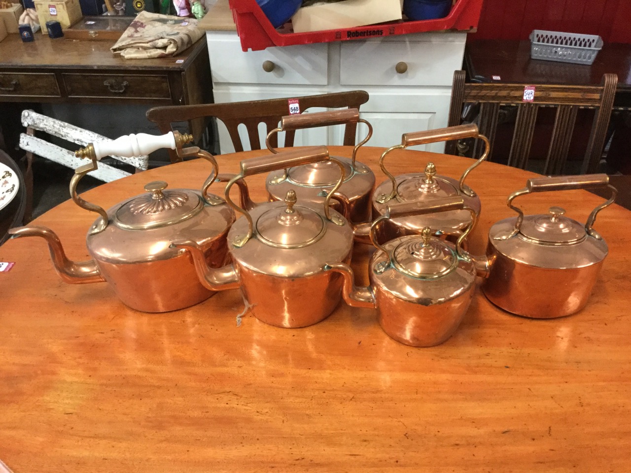 A collection of six Victorian copper kettles with riveted swan neck handles, oval & circular. (6)