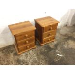 A pair of pine bedside cabinets, having scalloped moulded tops above three drawers mounted with