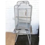 A birdcage on stand, the arched enclosure with three hinged doors having internal tray and shelf,