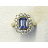 An 18ct gold sapphire & diamond ring, the emerald cut central sapphire weighing over one-and-a-