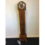 A walnut grandmother clock, the arched hood with chrome bezel having convex glass enclosing a