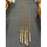 Four split cane fishing rods with cork handles made for W Temple having aluminium reel mounts; and a