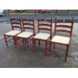 A set of four ladderback dining chairs, the turned cornerposts with knob finials, the upholstered