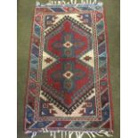 A Turkey rug woven with a pair of maltese cross style medallions on red hooked field framed by
