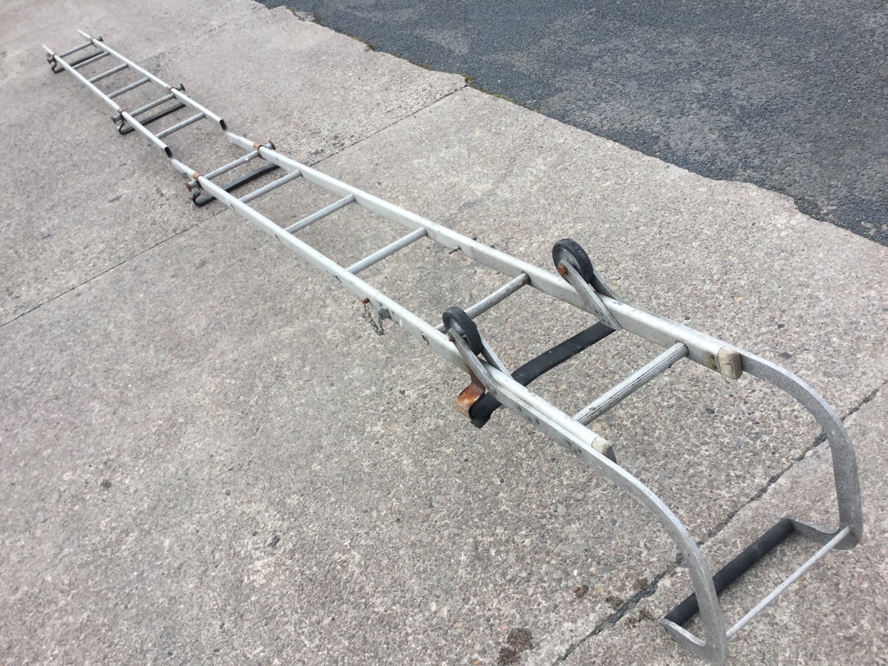 A Gravity Randall extending aluminium roof ladder with rollers and curved ridge bar, having