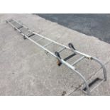 A Gravity Randall extending aluminium roof ladder with rollers and curved ridge bar, having