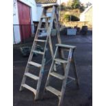 A set of wood step ladders with seven treads; and another smaller set with three ribbed treads. (2)