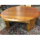 A circular mahogany coffee table, the plain moulded top on heavy block legs and rails. (48in x