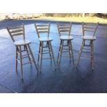 A set of four kitchen bar stools, the ladderbacks framed by angled ring-turned columns above rounded