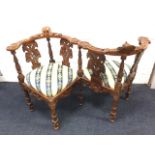 A carved mahogany conversation seat, the ‘him & her’ chairs having captains style back rails