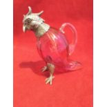 A small cranberry glass claret jug modelled as a parrot with silver plated mounts to ribbed body,
