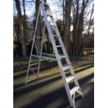 A set of tall tapering aluminium step ladders with eight ribbed treads. (86in)