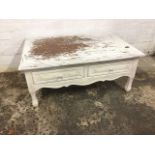A painted hardwood coffee table having rectangular moulded top above two panel carved frieze