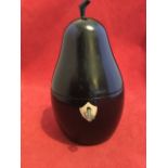 An ebonised pear shaped tea caddy with protruding stalk, the hinged lid revealing a silvered