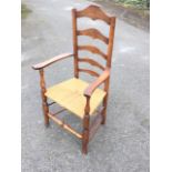 A nineteenth century oak ladderback armchair, with hooped rails above shaped platform arms on turned