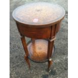 A circular leather mounted occasional table, the drum top with frieze drawer raised on rectangular
