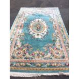 A massive Chinese thick pile wool carpet, woven with central oval floral medallion in turquoise