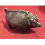 A bronze clockwork pig desk bell, the animal with inlaid eyes having snout and tail ringing bell. (