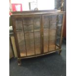 A bowfronted glazed mahogany china cabinet, with astragel glazed doors enclosing glass shelves,