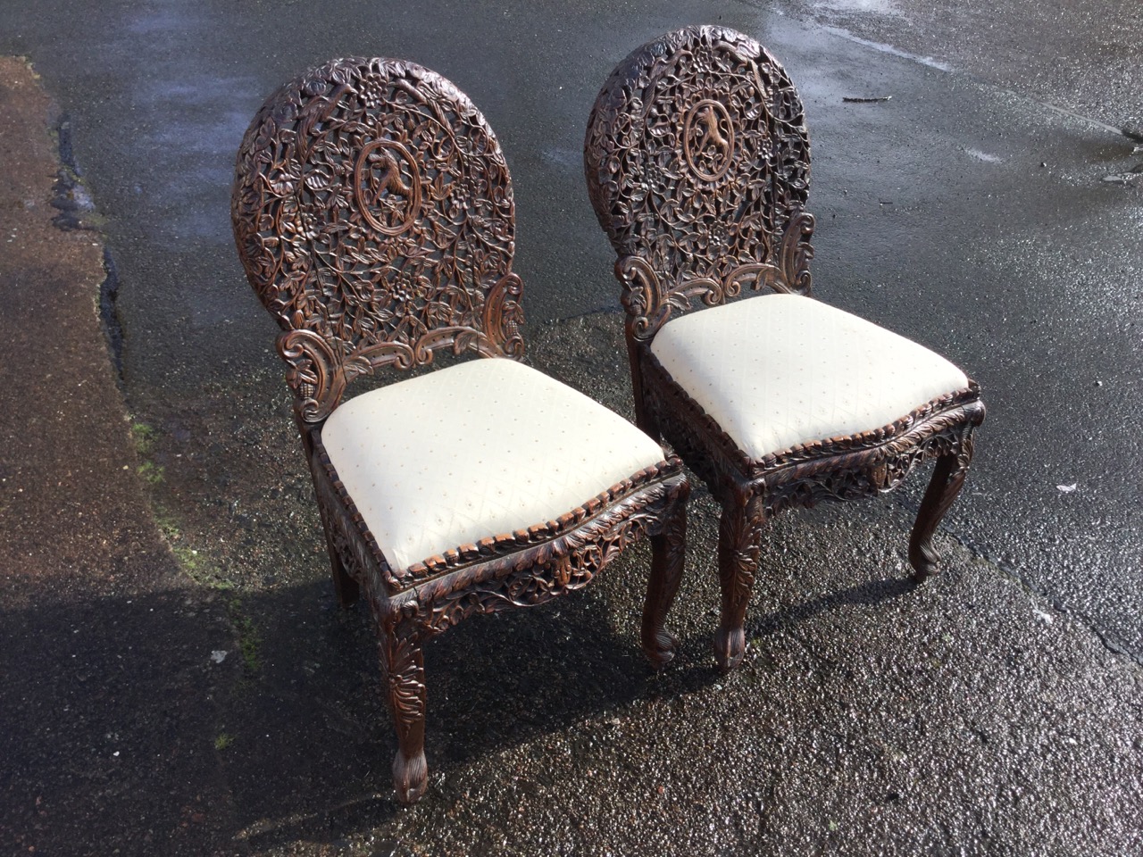 A pair of Victorian Anglo-Indian chairs, the oval backs carved with pierced floral decoration with