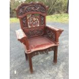 A Japanese carved armchair, the scalloped back with panels of birds framing a pierced pentagonal