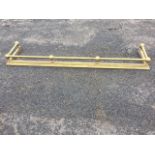 A brass fender, the moulded curb mounted with ball supports with tubular rail. (60in x 14in)
