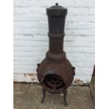 A cast iron pot-bellied chimera stove, the burning chamber with ring handles on shaped legs, the