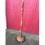A heavy hardwood standard lamp, with turned column on circular moulded base with three ball feet. (