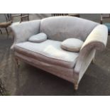 A contemporary upholstered sofa with arched padded back and scrolled arms above loose cushion with