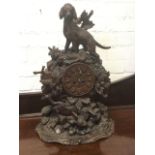 A carved Victorian black forrest clock, the case surmounted by a hound standing on naturalistic