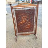 An arts & crafts oak firescreen with handle to rail having square tapering columns with flat moulded