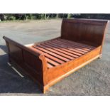 A contemporary mahogany king size sleigh bed, with curved twin panelled headboard & tailboard joined