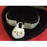 A silver chain bracelet mounted with an agate lock in the form of an owl with inlaid glass eyes, the