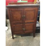 An Edwardian stained cupboard, the rectangular top with upstand above four panelled doors