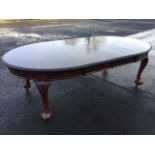 A late Victorian mahogany dining table, having telescopic action with two spare leaves, the top with