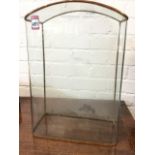 An early nineteenth century rounded glass dome of arched form with flat back, the corners with