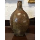 A large antique ovoid salt glazed bellarmine jar with moulded rim and loop handle to shoulder,