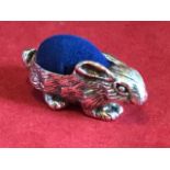 A novelty silver rabbit pin cushion, the animal with soft back - Sterling mark. (1.5in)