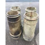 A set of four stoneware chimney pots, the tapering ring cast columns on plinth bases. (30in) (4)