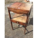 A Georgian mahogany washstand, the hinged tray top revealing an interior cut for bowls above