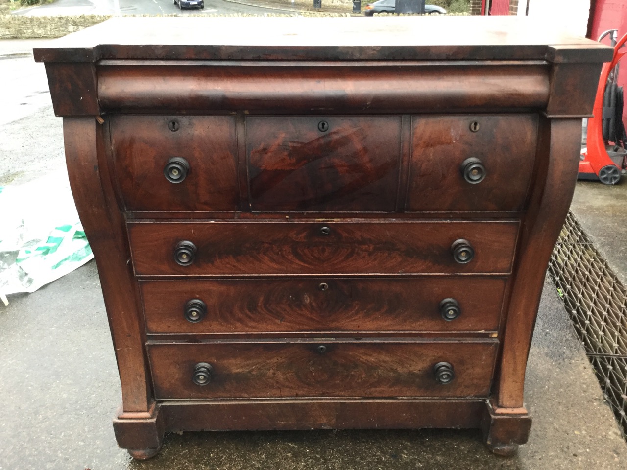 A Victorian mahogany chest of drawers, the top of inverted breakfront outline above a long cushion