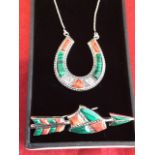 A Sterling silver coral and malachite horseshoe pendant, the stone panels with beaded borders,