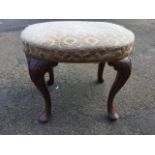 An oval Georgian walnut stool, the upholstered seat on acanthus carved cockbeaded cabriole legs with