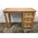 A pine desk with rectangular top above a kneehole, flanked by three panelled drawers. (41in x 18in x